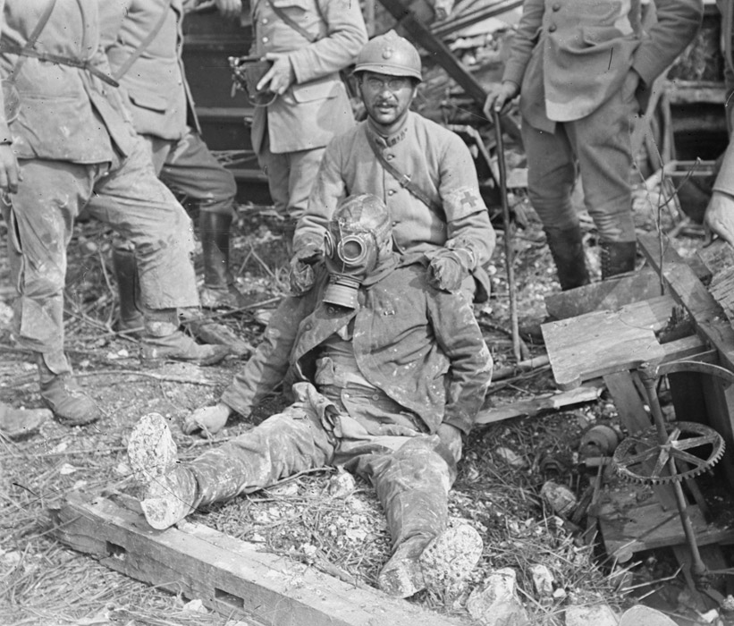 A stretcher-bearer props up a dead German soldier.