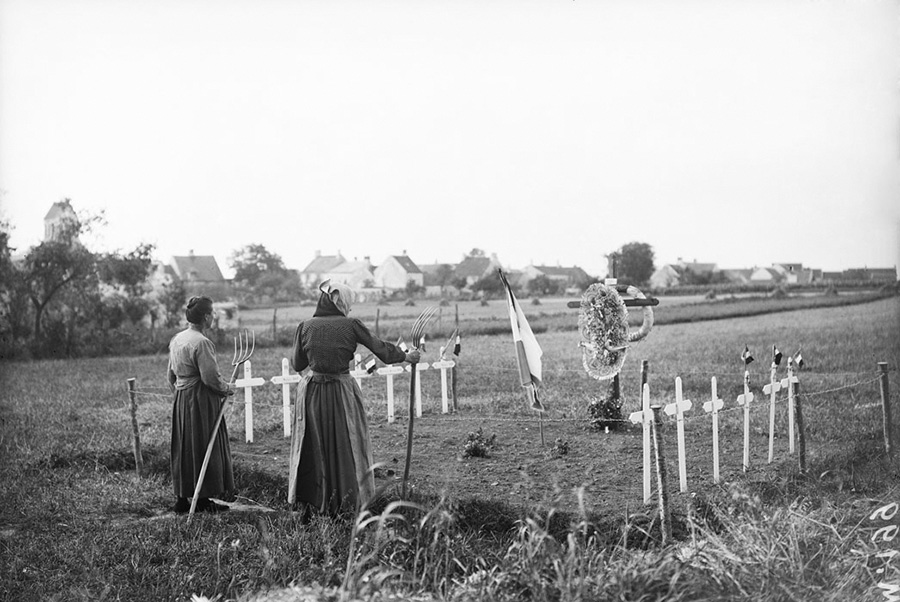 Civilians upkeep a grave plot.