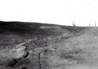 A haunting image showing a trench cutting its way across the devastated ground. Verdun.