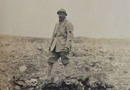 Human remains decomposing in and alongside a shell-hole.